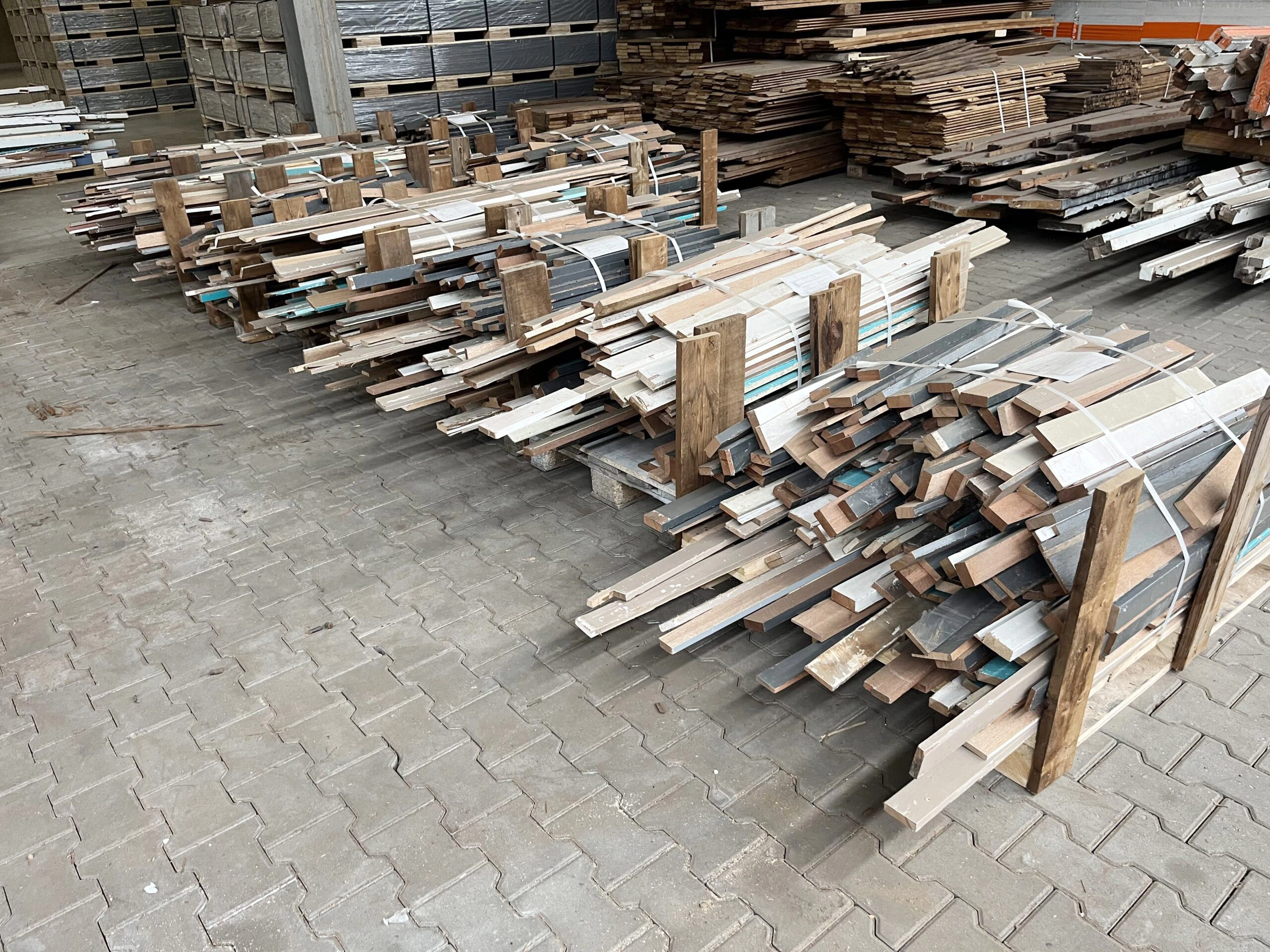 Gesorteerde stapels hergebruikt hout op de werf van CirQ Wood voor hout recyclen